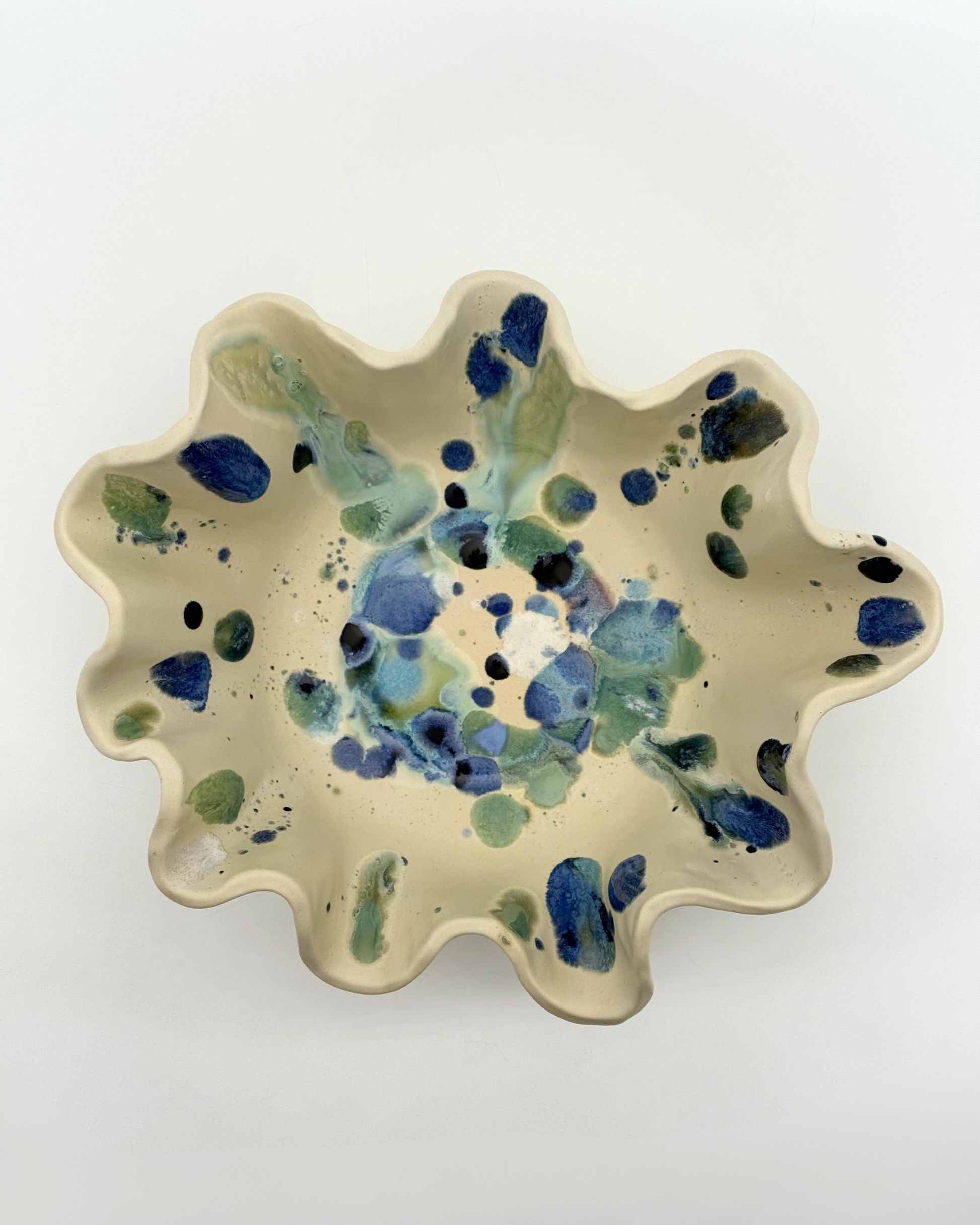 Sculptural stoneware serving bowl with flowing rim and layered glaze detail